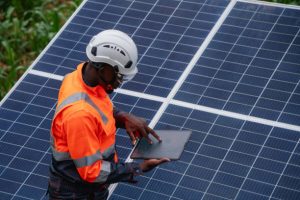 Service engineer inspects and maintains solar panels in a cultivation area, promoting clean energy.